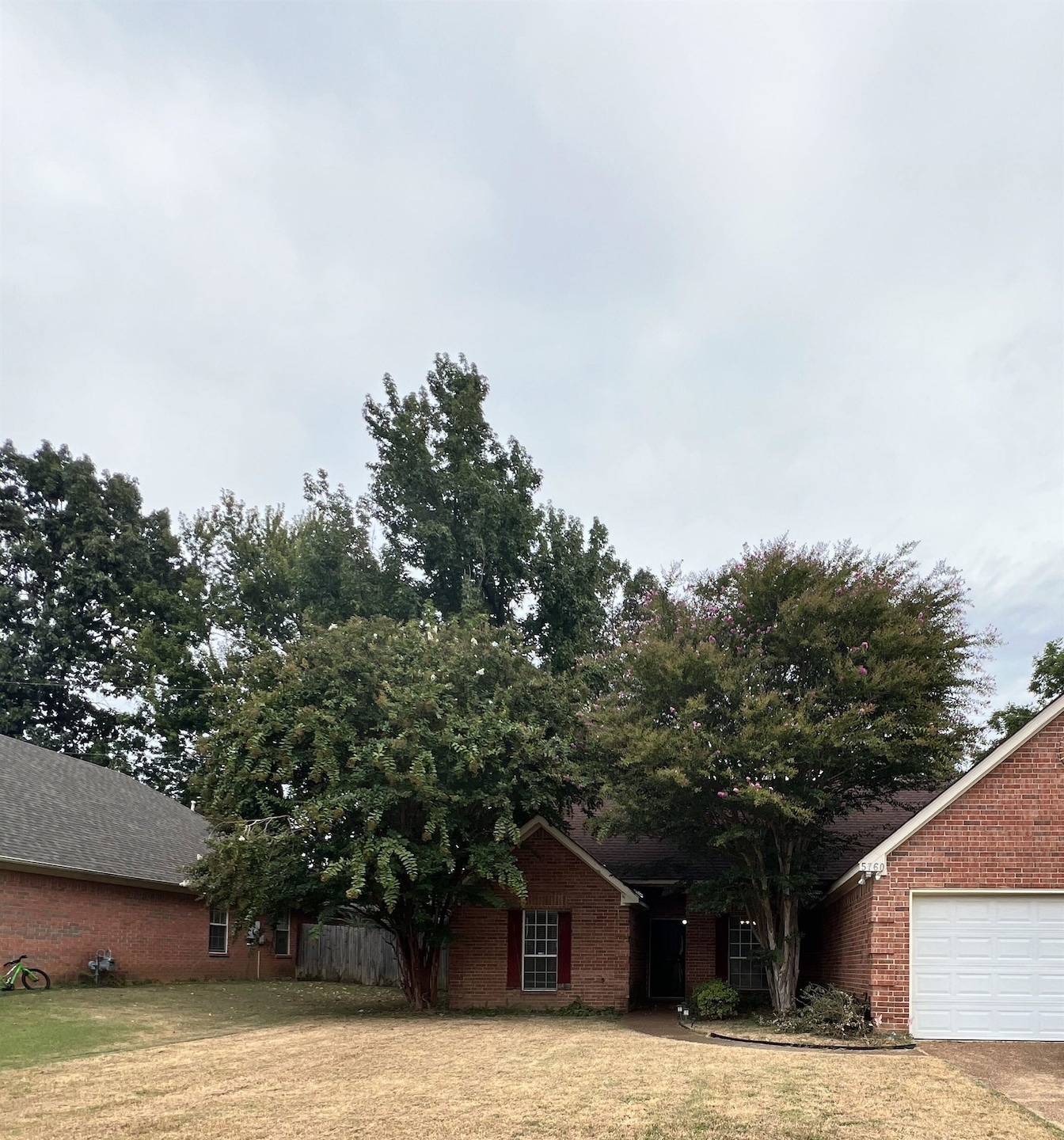 View of front facade with brick siding and a garage