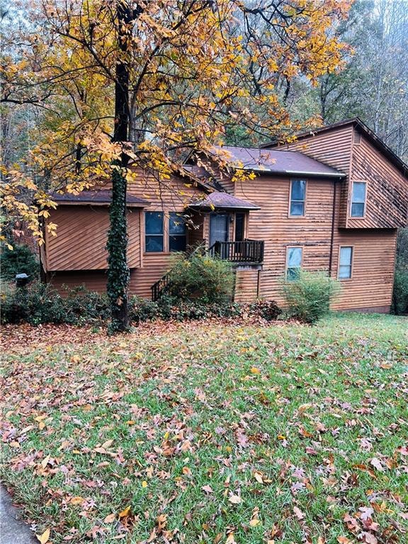 View of property exterior with a lawn