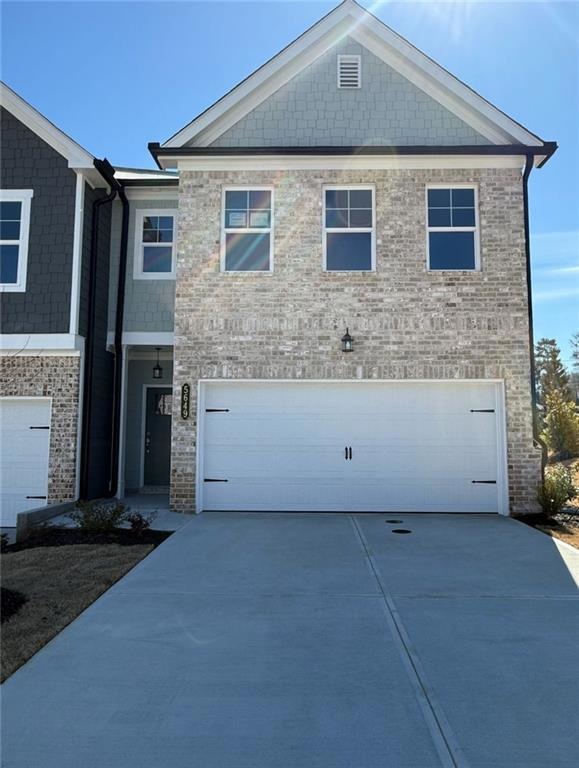 View of front facade featuring driveway and a garage