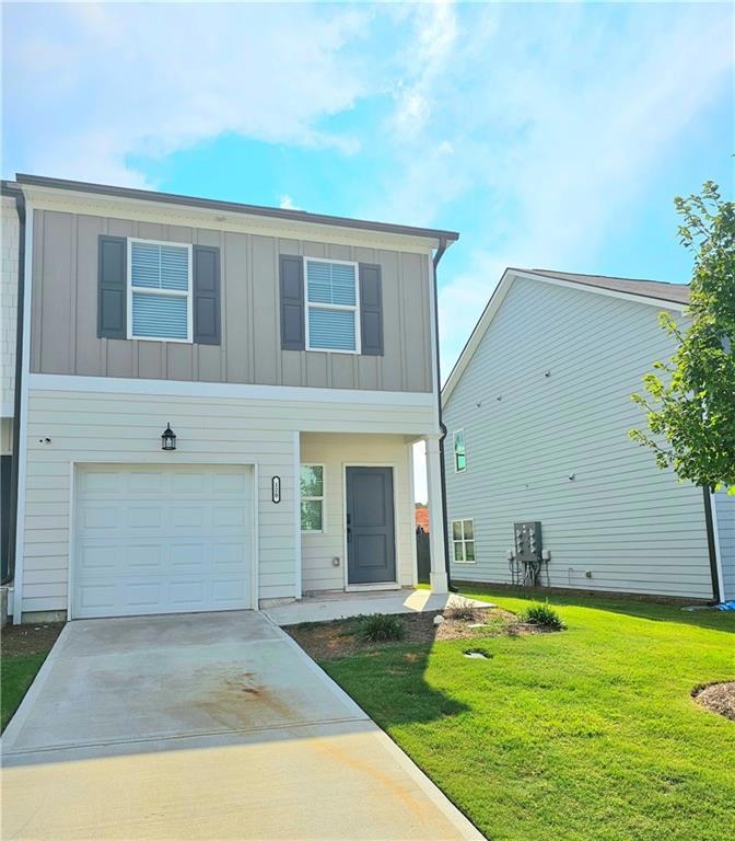 View of front of house with a garage, board and ba