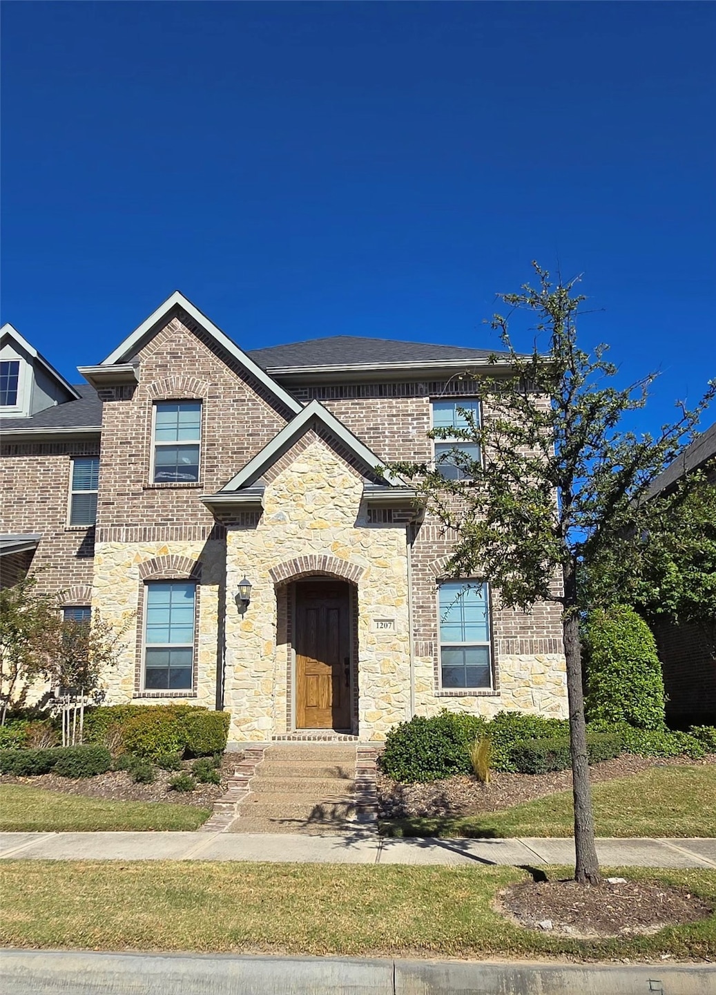 View of front facade with brick siding and stone siding