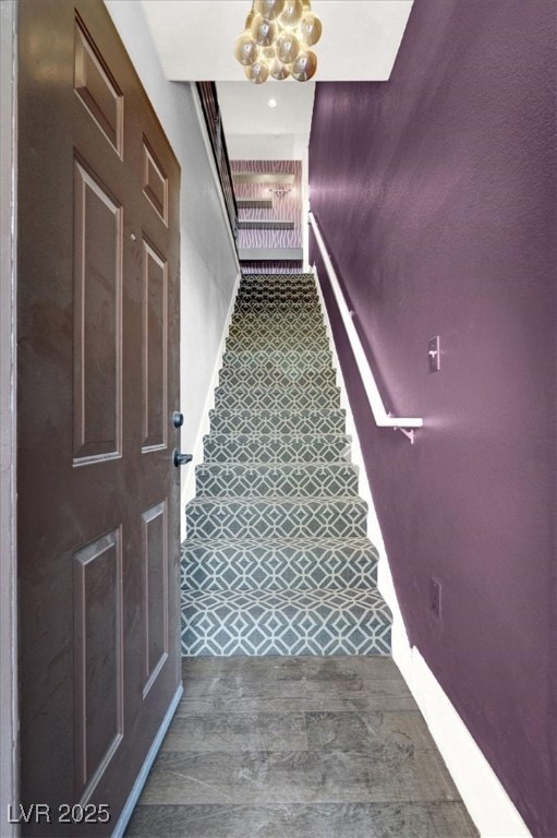 Stairs featuring baseboards and an inviting chandelier