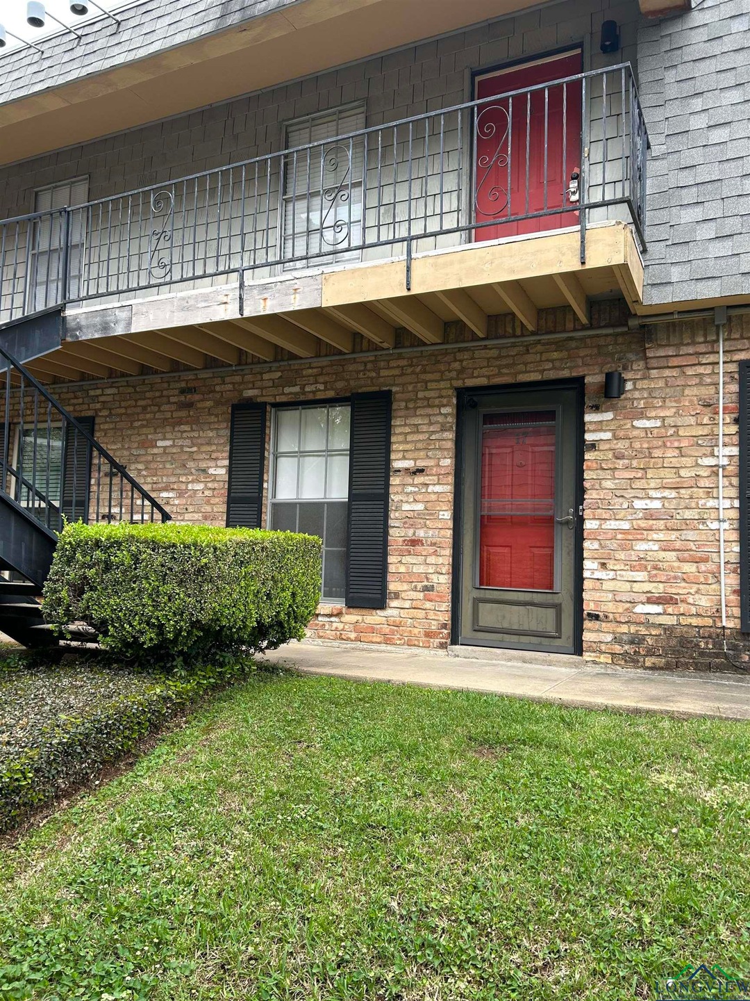 Property entrance with a lawn, brick siding, roof 