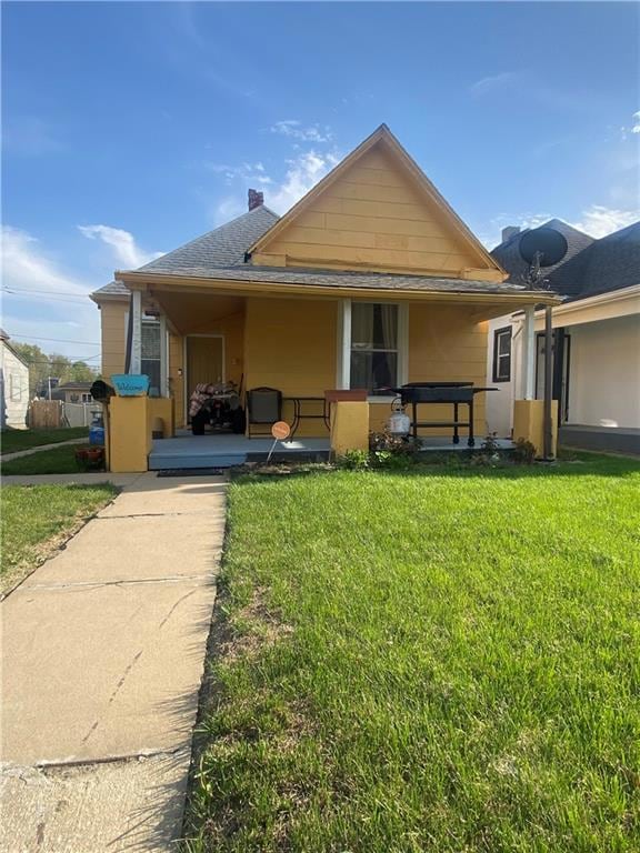 Farmhouse-style home featuring a front lawn and roof with shingles