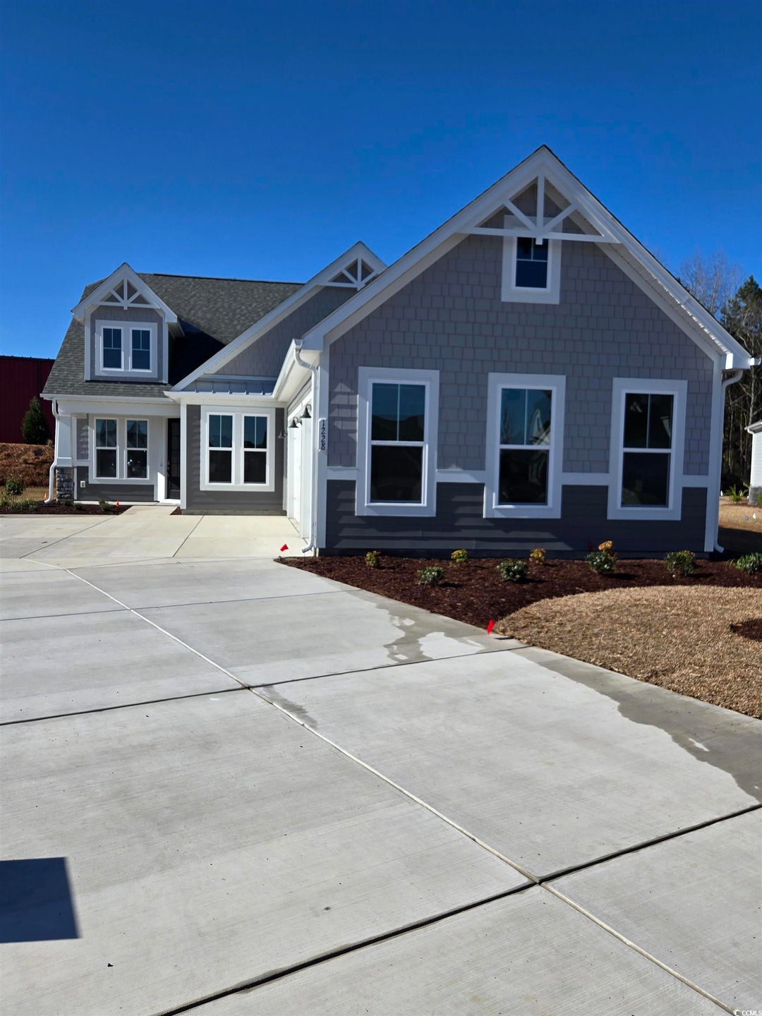 View of front of property with driveway and roof w