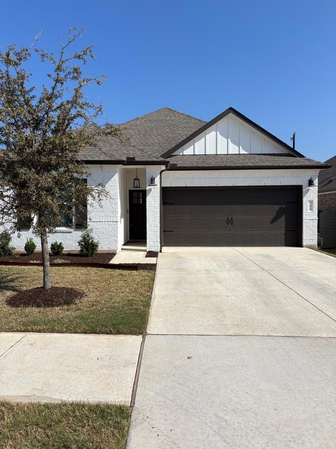 View of front of house featuring an attached garage, brick siding, and concrete driveway
