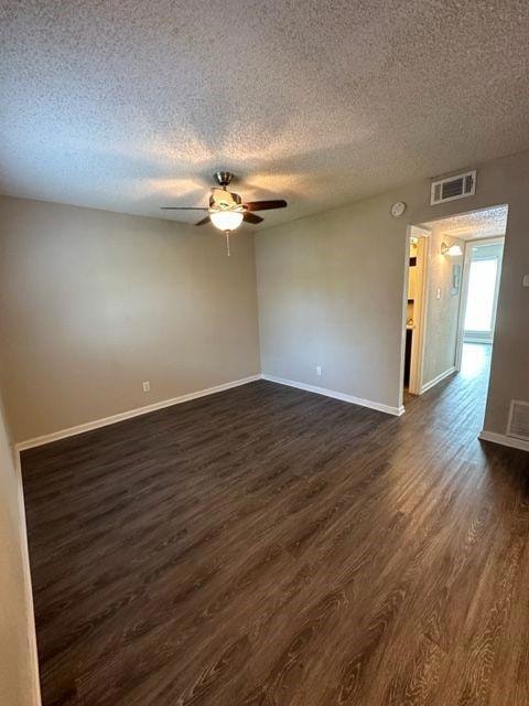 Unfurnished room featuring baseboards, dark wood-
