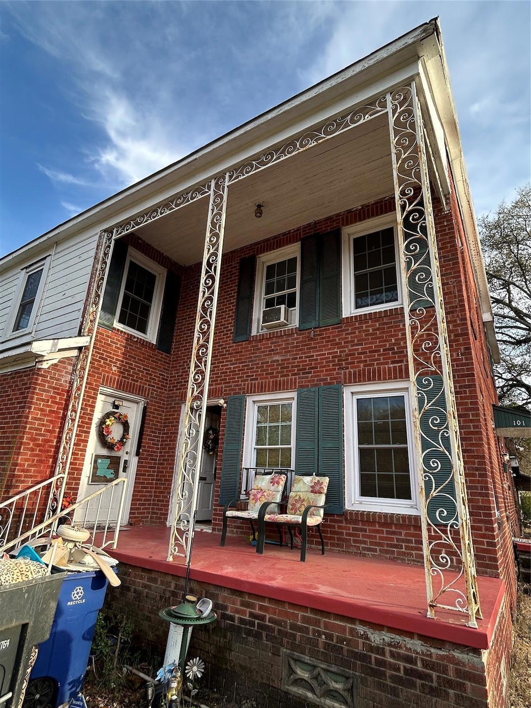 Rear view of house with a porch and brick siding