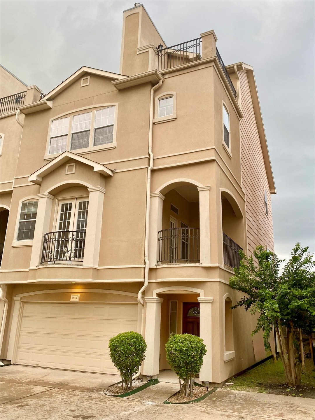 A modern townhouse with a light-color exterior, fe
