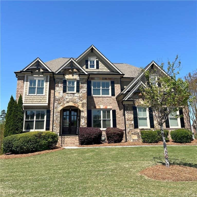 Craftsman-style house with a front yard and stone 