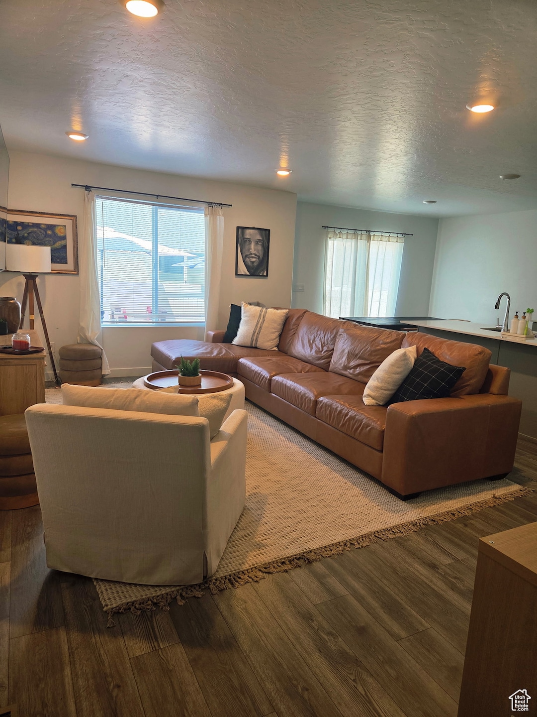 Living room with a textured ceiling, laminate floors, and recessed lighting