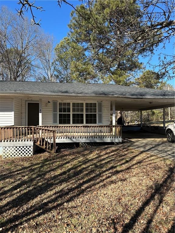 View of front of home with a carport and a front y