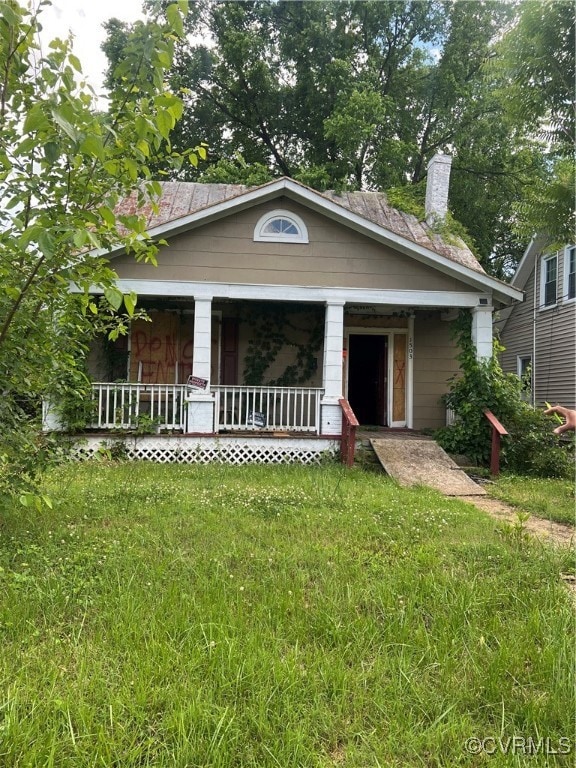 View of front of house with covered porch, a chimn