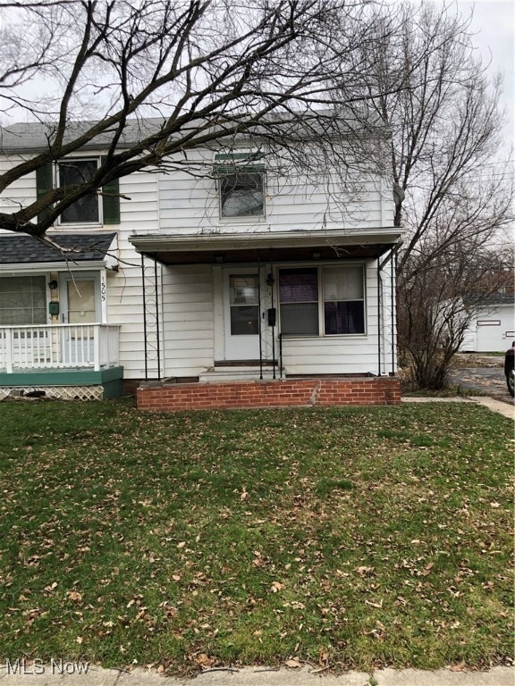 View of front facade featuring a front yard and covered porch
