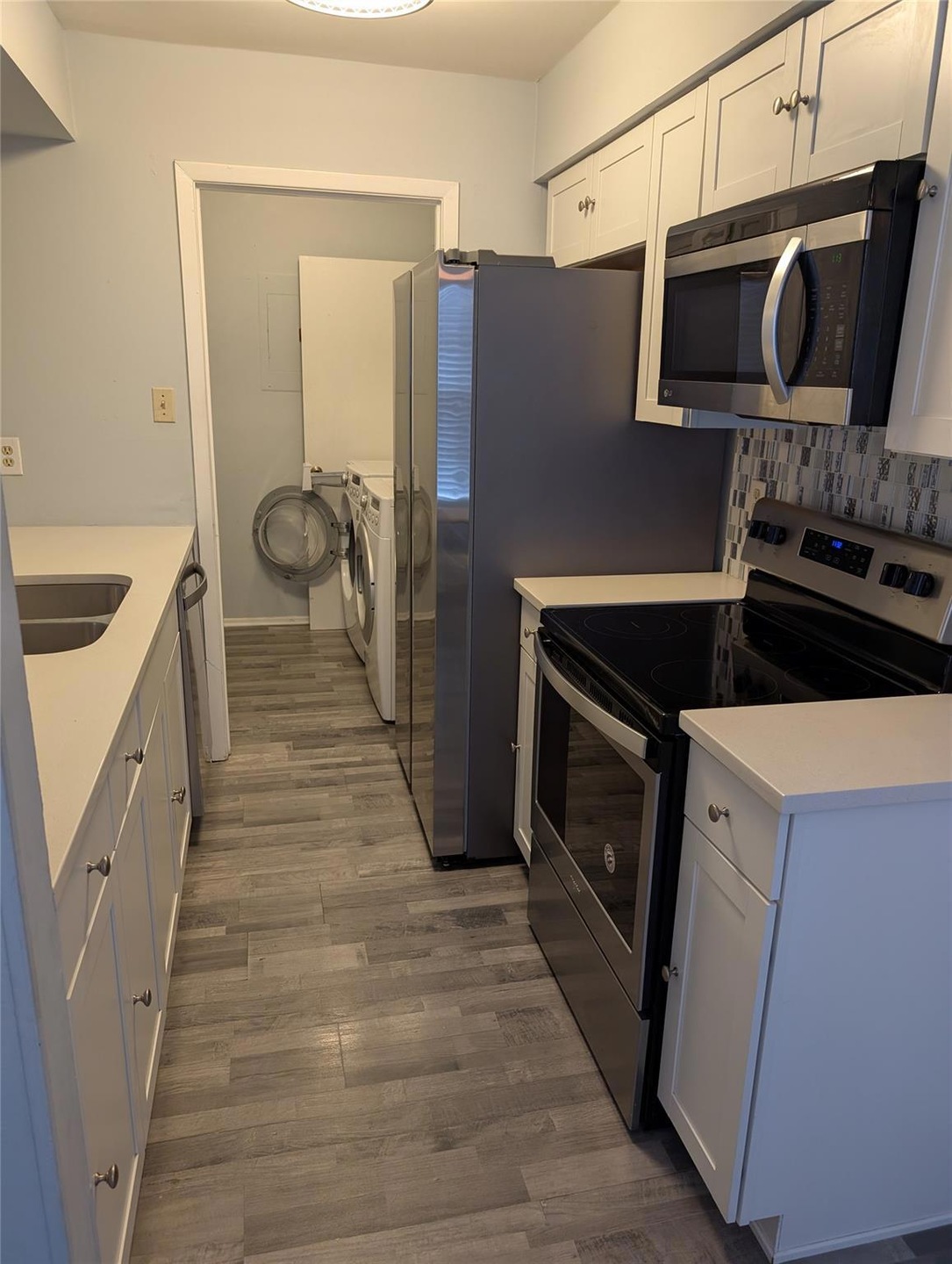 Kitchen with washer and dryer, wood finished floo