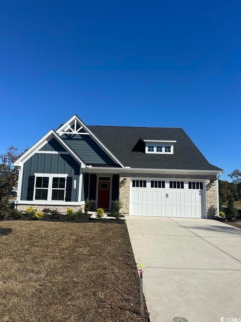 Craftsman-style home featuring driveway, board and batten siding, and an attached garage