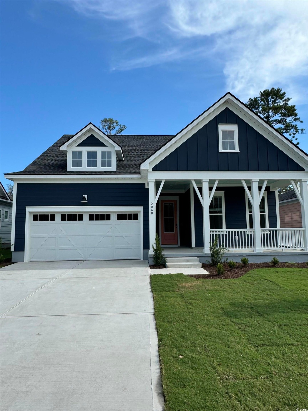 View of front of house with a garage, a front yard, and a porch