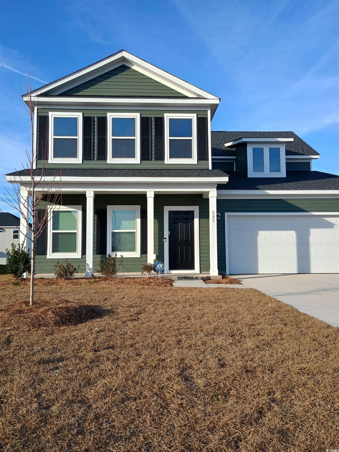 View of front of home with a garage and covered po