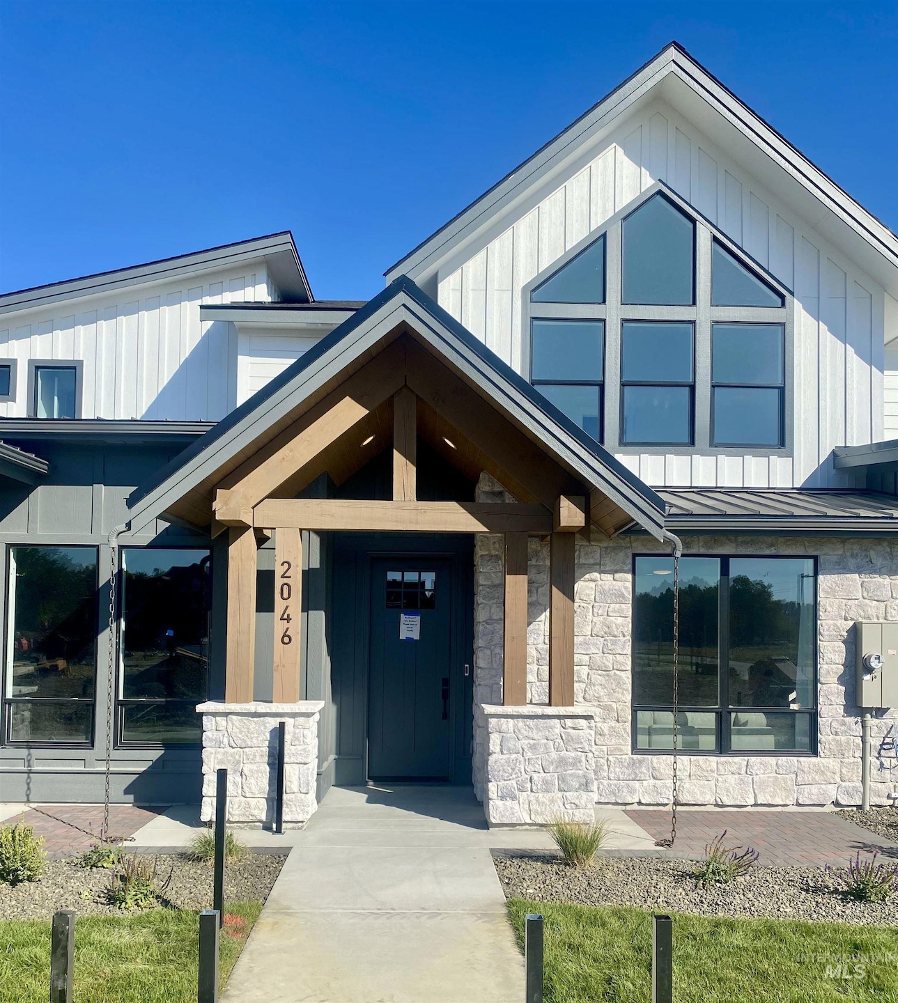 View of exterior entry with stone siding, a standing seam roof, and a metal roof