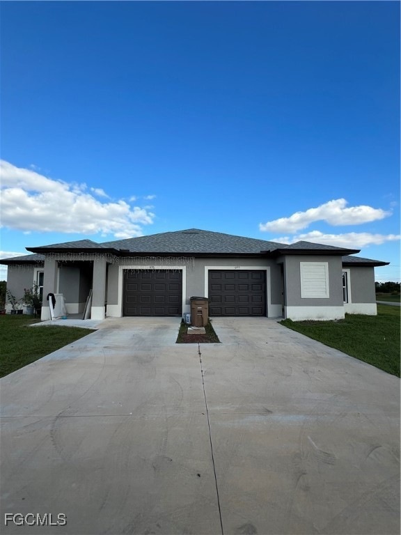 View of front of home with stucco siding, driveway, a front lawn, an attached garage, and a shingled roof