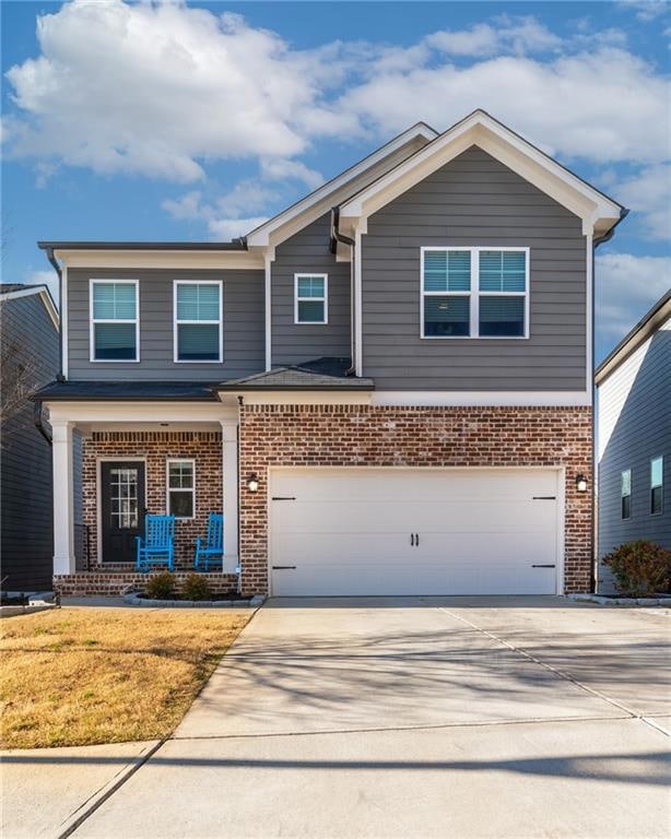 Craftsman-style home with concrete driveway, brick