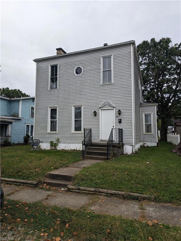 Back of house featuring a yard