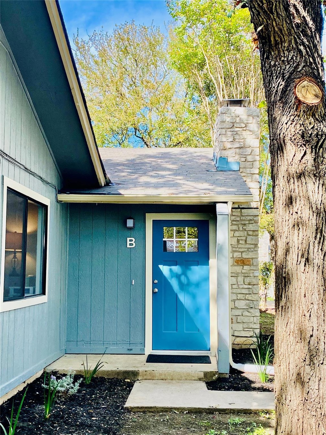 Property entrance featuring a chimney and roof with shingles