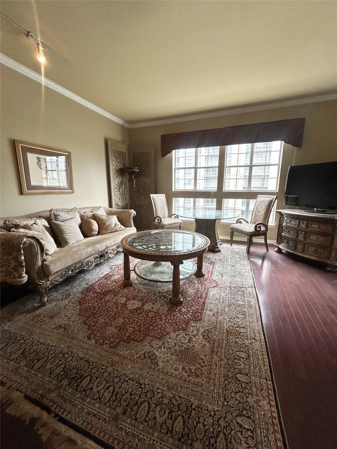 Living area with ornamental molding and track lighting