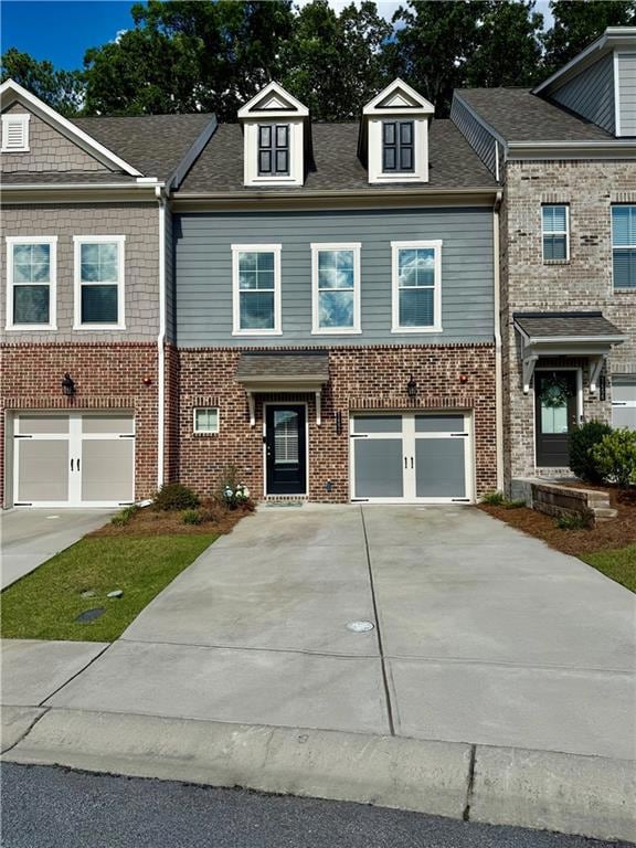 Townhome / multi-family property featuring driveway, brick siding, and a garage