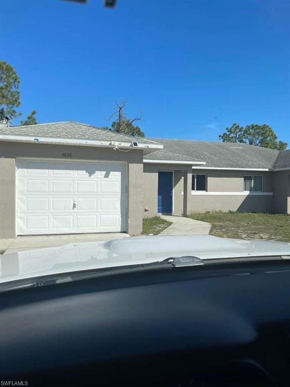 Ranch-style home featuring stucco siding and an attached garage