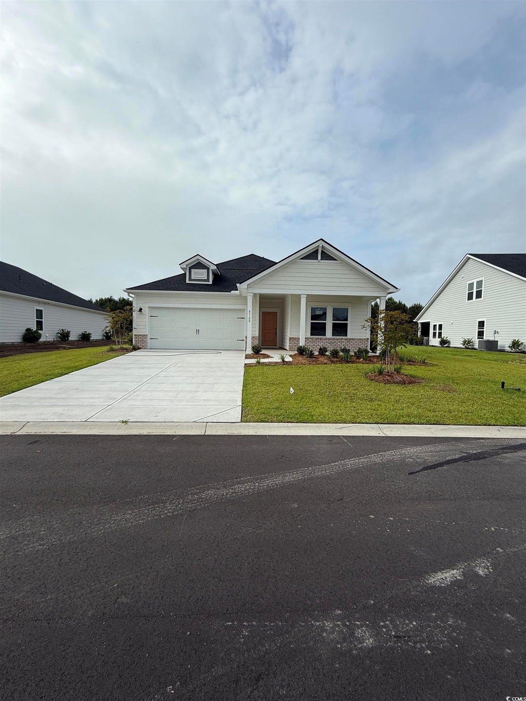 View of front of home with driveway, a front yard, and an attached garage