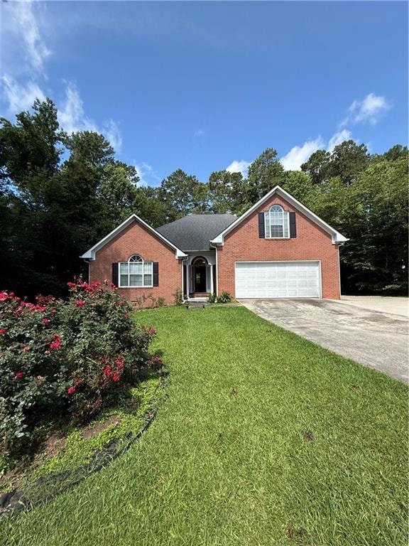 View of front of property featuring brick siding, concrete driveway, and a front lawn