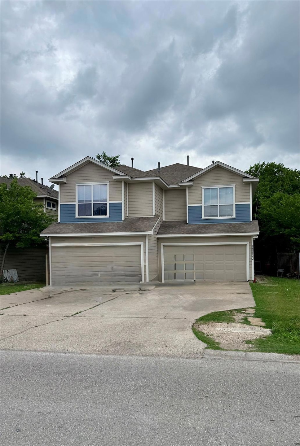 View of front facade featuring a garage, fence, a