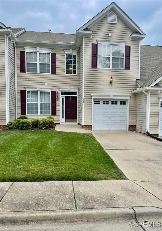 View of front of home with a garage and a front yard