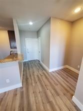 Corridor with wood finished floors and baseboards