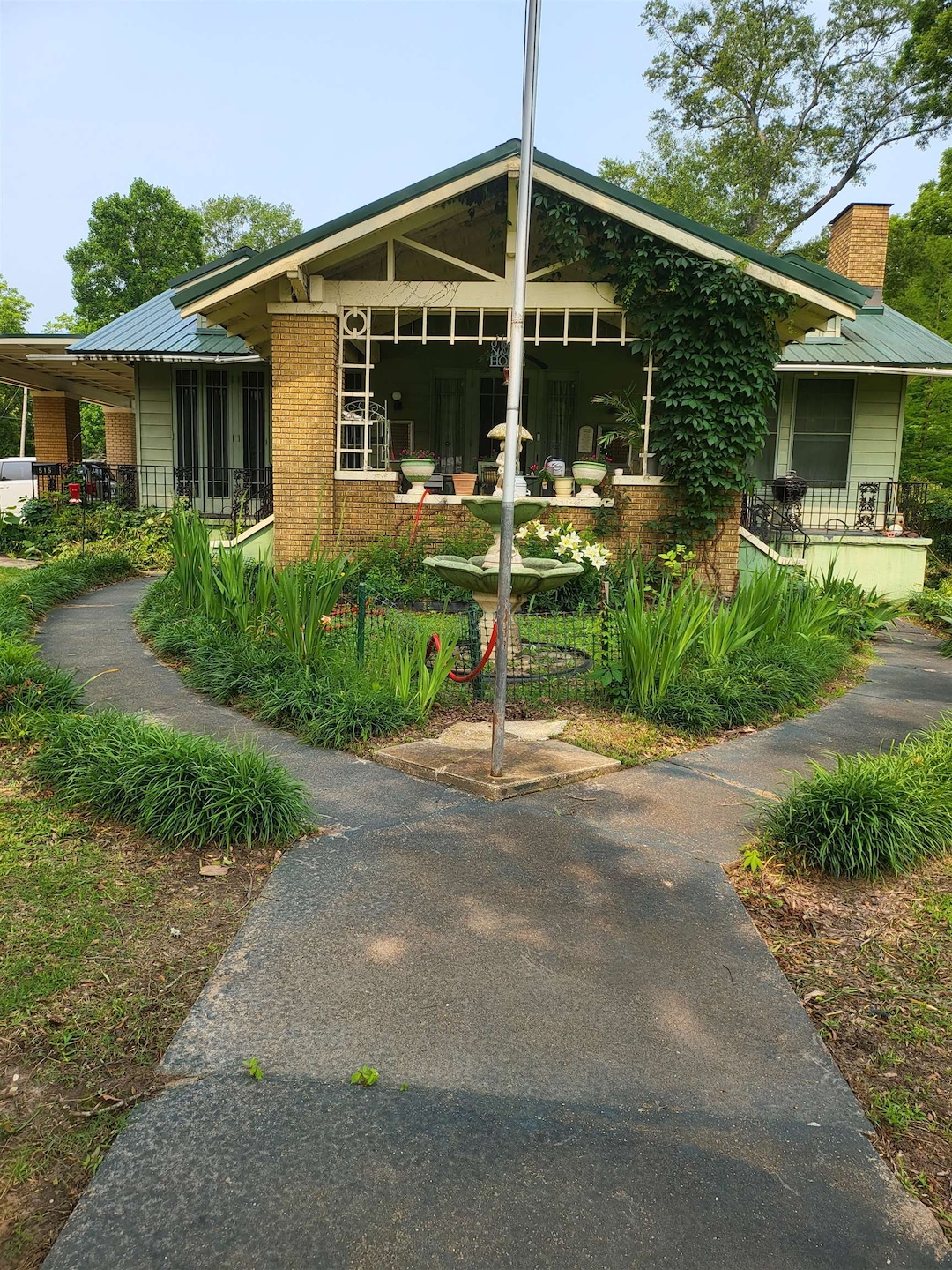View of front of home with brick siding, a chimney, and a metal roof