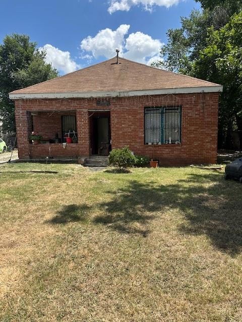 Back of property featuring a lawn