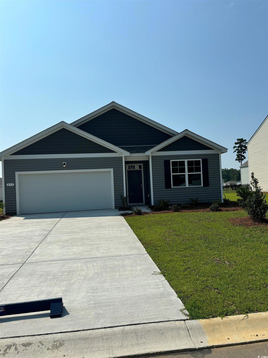 Single story home featuring a front yard and a gar