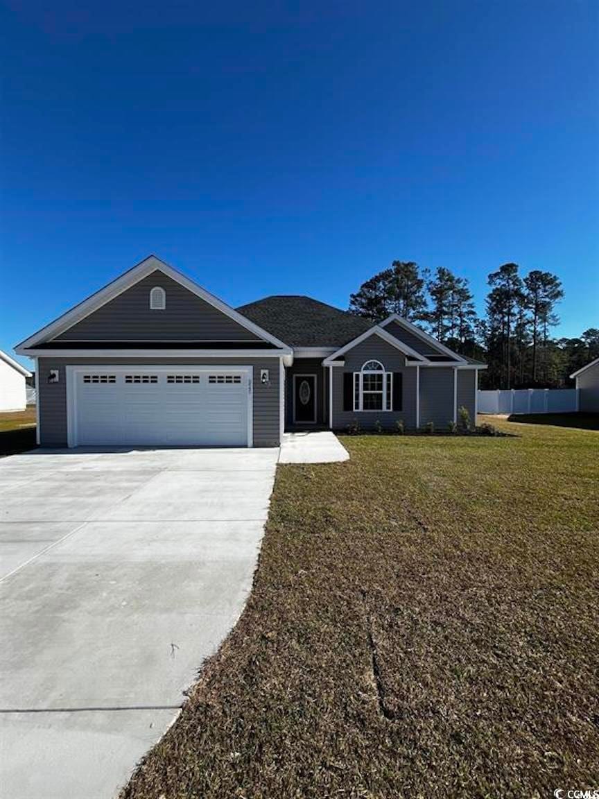 Single story home featuring concrete driveway and an attached garage