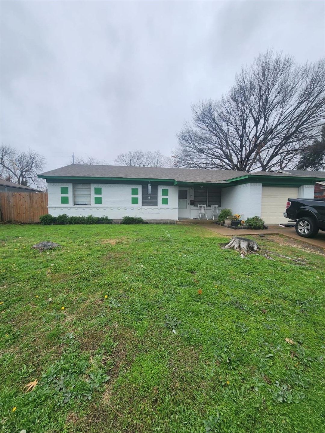 Single story home with a garage and a front lawn