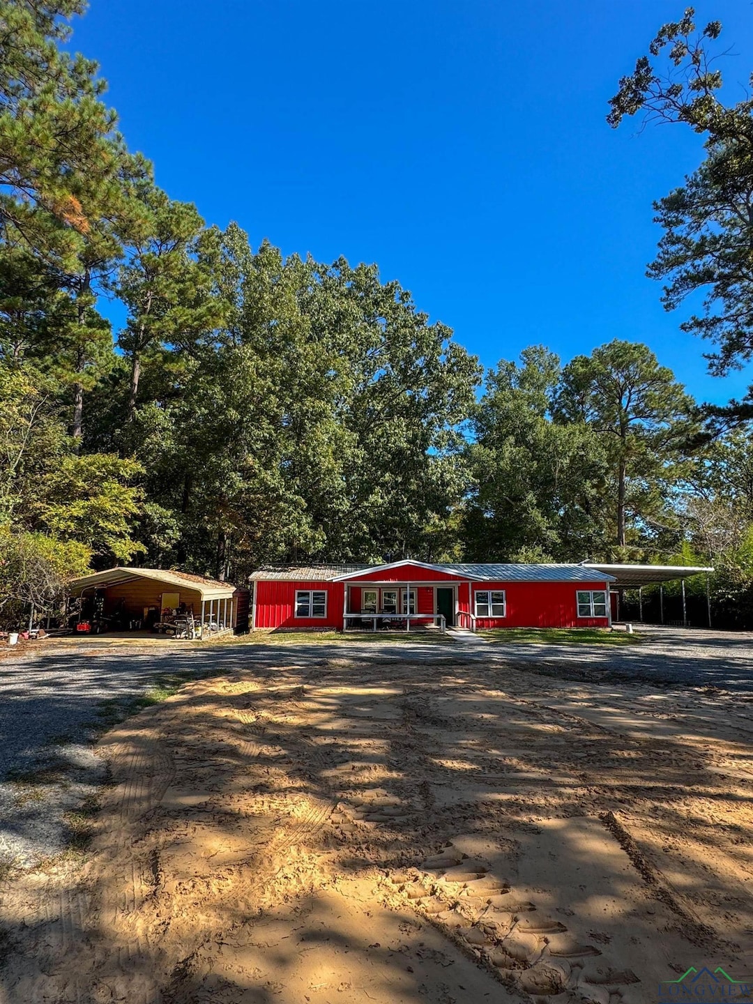 View of front of house with driveway, covered porch, and a carport