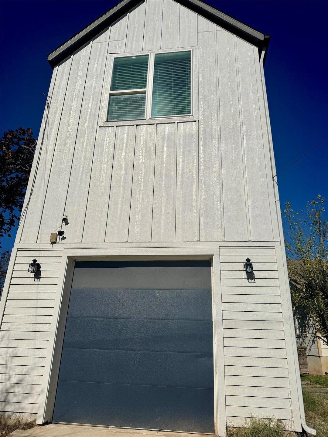 View of side of property with a garage and an outbuilding