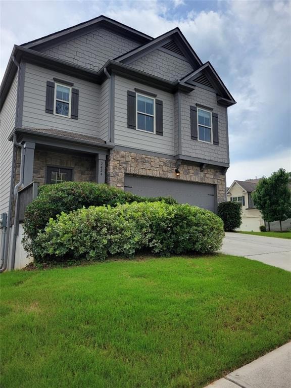 Craftsman inspired home featuring a garage, stone siding, a front lawn, and concrete driveway