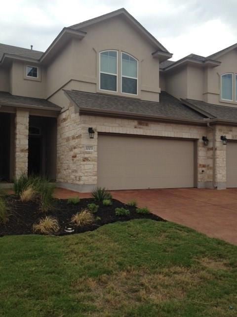 View of front of home with a garage, stone siding