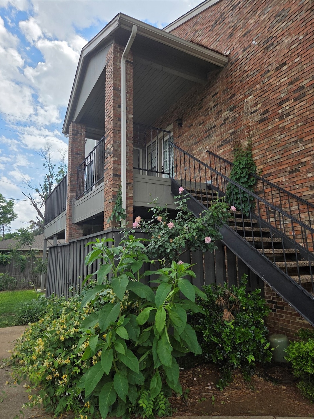 View of side of property featuring stairway and brick siding