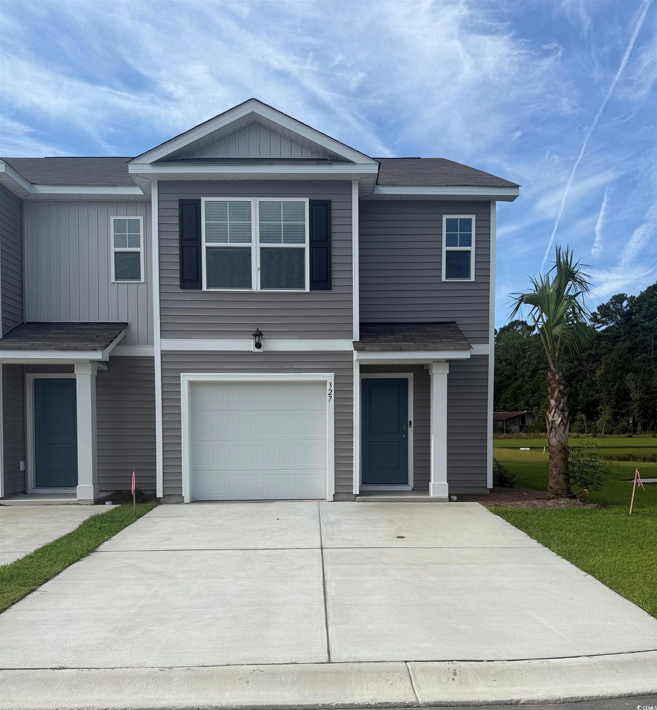 View of front of house featuring an attached garage, concrete driveway, roof with shingles, and board and batten siding
