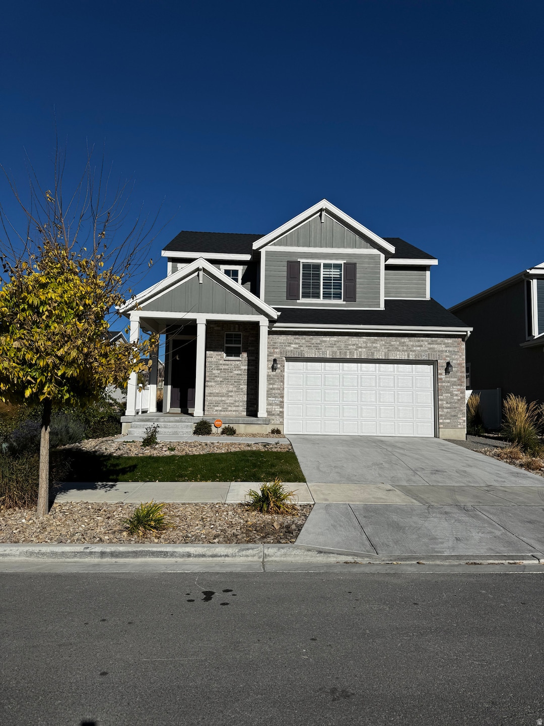 Craftsman-style house with a porch, concrete driveway, a garage, and board and batten siding