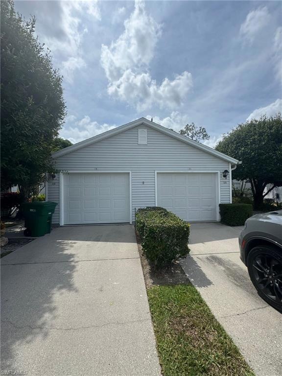 Detached garage featuring concrete driveway