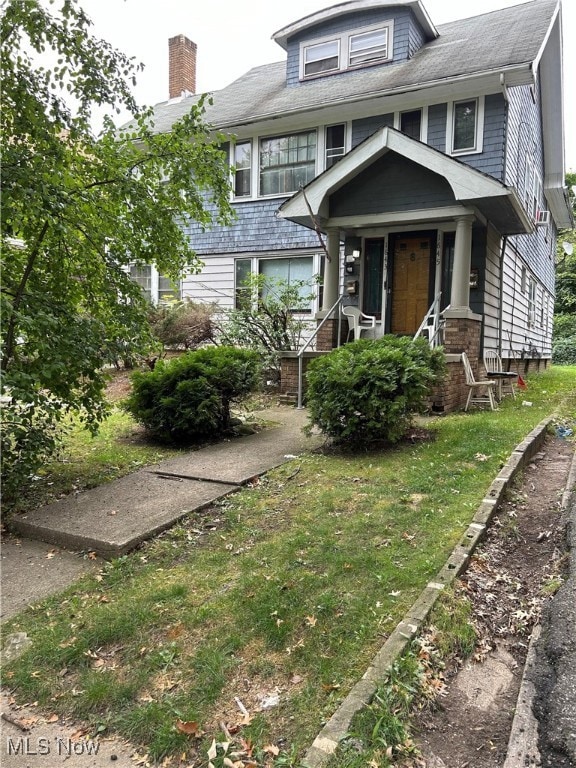 View of front of home with a front yard and a porch