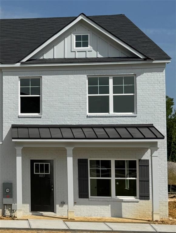 View of front facade with brick siding, board and 